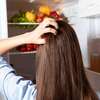 Femme face à un frigo ouvert illustrant la réflexion autour de la faim physiologique