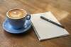 Un cahier ouvert, avec un stylo baigné dans une lumière douce qui invite à l’écriture et à l’introspection