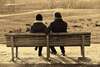 Deux personnes assises sur un banc échangeant dans un moment d'écoute et de réflexion, illustrant l'importance du regard extérieur dans un cheminement personnel.