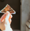 Regard reflété dans un fragment de miroir évoquant la remise en question de l'identité lors d'un passage de vie.