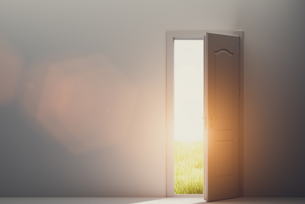 Porte ouverte laissant entrer la lumière, symbole d'un passage de vie et d'une transition personnelle.