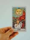 Main tenant une carte de tarot, illustrant la rencontre avec un symbole