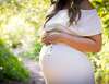 Femme enceinte en robe blanche pratiquant réflexologie bébé émotionnelle