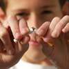 Jeune homme coupant une cigarette