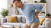 Homme souffrant de mal de dos dans un salon moderne