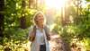 Femme souriante en forêt symbolisant détente cervicale en nature