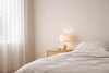 Chambre épurée et apaisante avec literie sobre, lumière douce et ambiance minimaliste — espace de récupération optimale