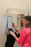 Radiographie panoramique : assistante installant une patiente dans l'appareil