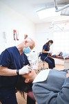Soin orthodontique au fauteuil, assistante en arrière-plan