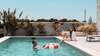 Famille heureuse profitant piscine sous ciel bleu clair
