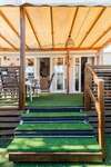 Mobil home blanc avec terrasse en bois et transats jaunes