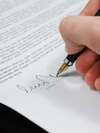 Main signant contrat de travail avec stylo plume doré