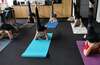 Personnes pratiquant yoga ensemble en entreprise pour cohésion