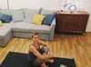 Personne pratiquant yoga à la maison avec cours en ligne