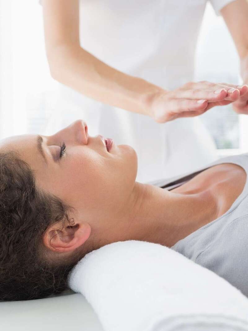 Le travail d'un magnétiseur qui magnétise la zone claviculaire d'une personne allongée sur le dos