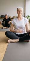 Femme en tenue Pilates assise sur ballon dexercice gris