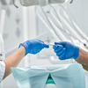 Professionnels médicaux échangeant instrument chirurgical en cabinet dentaire