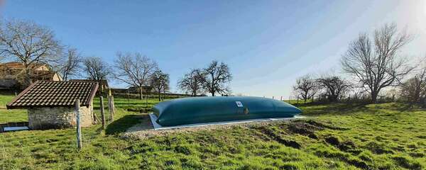 Citerne souple de grande capacité installée en milieu rural, utilisée pour la récupération d'eau de pluie, le stockage d'effluents agricoles ou industriels, ou encore pour de l'eau potable ou non potable. 