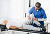 Physiothérapeute examinant genou patient après prothèse totale