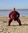 personnes pratiquant qi gong sur plage