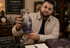 Expert évaluant un vase ancien pour estimation honnête