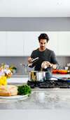 Homme préparant un repas sain dans une cuisine moderne illustrant le bilan diététique personnalisé