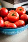 Bol bleu sculpté contenant des tomates fraîches en plan rapproché pour consultation en duo