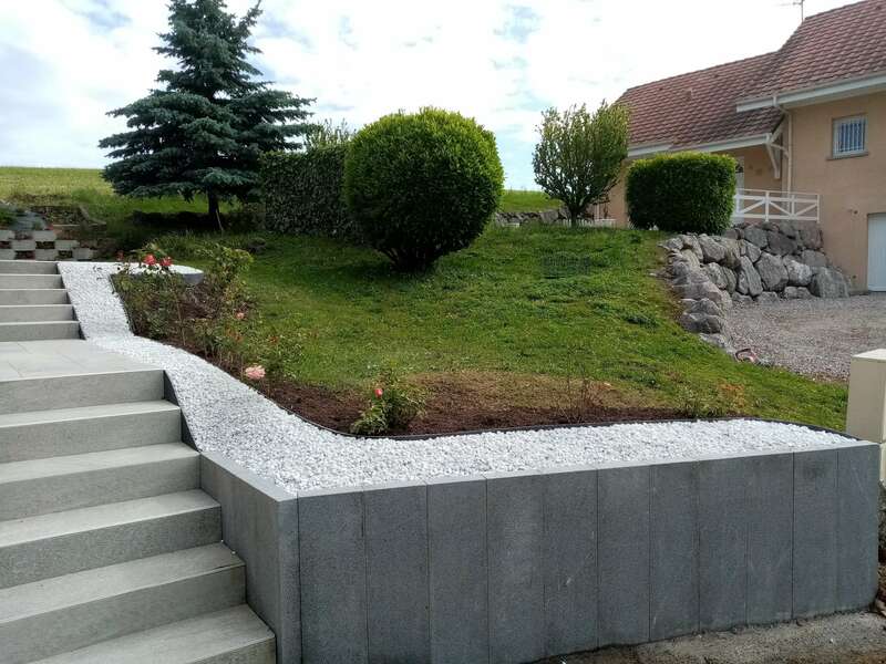Muret en blocs de granit et contour en gravier blanc / béton lavé