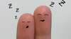 fingers with drawing of sleeping face