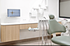 Salle de soins avec fauteuil dentaire et écran
