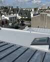 façade immeuble crème arcades volets rouges ciel clair