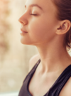 Femme détendue allongée yeux fermés illustrant relaxation et gestion du stress en sophrologie