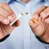 Personne tenant une cigarette illustrant le geste rituel du tabac