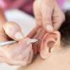 Stimulation auriculothérapie avec stylet sur oreille en intérieur