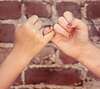 Deux mains liées en pinky promise symbolisant confiance et engagement dans l'expérience du silence
