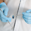 Chirurgien dentiste souriante en blouse tenant outils dentaires