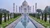 Vue panoramique du Taj Mahal entouré de jardins et de plans d'eau, symbole de l'Inde.