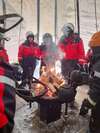 Personnes réunies autour feu chaud en plein hiver neigeux