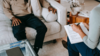 Un homme assis sur un canapé qui discute avec une thérapeute qui prend des notes