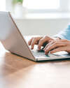 Personne tapant sur ordinateur pour assurance dommages ouvrage