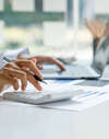 Personne utilisant calculatrice bureau projets immobiliers
