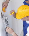 Électricien qualifié connectant gaines et fils électriques chantier