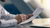 Homme lisant contrat de travail avec ordinateur portable