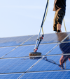 Homme nettoyant panneaux solaires sur toit dans processus nettoyage
