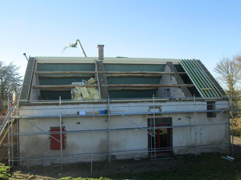 Restauration d'une maison ancienne avec pannes en chêne conservées et redressées.