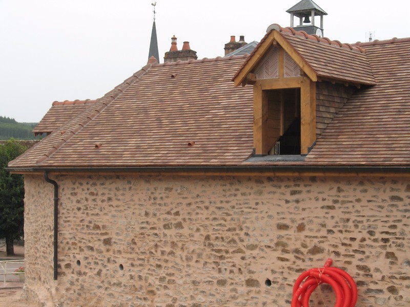 Lucarne à chevalet lasurée, habillée en brique et tuile plate.