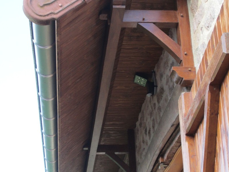 Prolongement d'un pan de toiture de 1 mètre avec consoles et sablière en chêne.