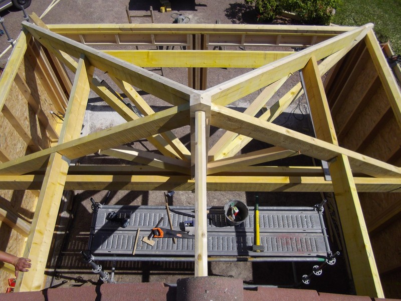 Vue de dessus d'une charpente avec croupe en sapin traité pour un garage.