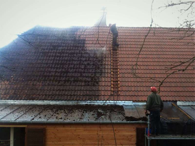 Démoussage d'un toit en tuile béton.
