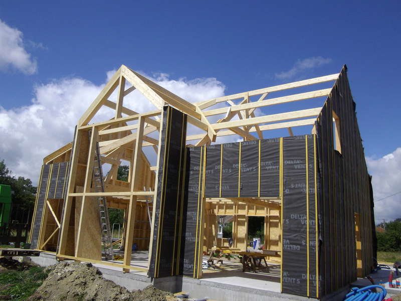 Charpente apparente en sapin raboté et lamellé-collé sur maison en ossature bois. Pendant les travaux...